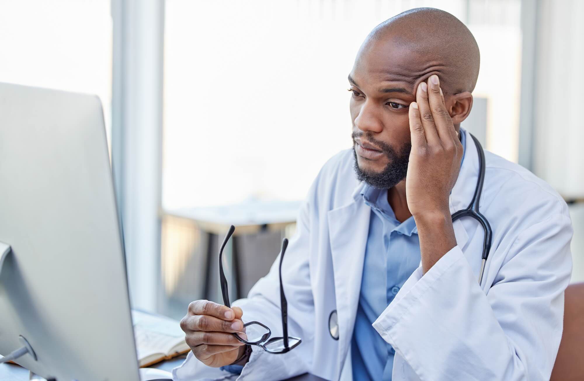 Stressed doctor in front of his computer because his website was negatively hit by Google update